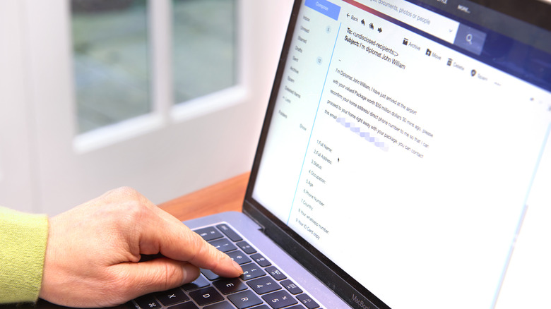 A hand pressing a laptop key