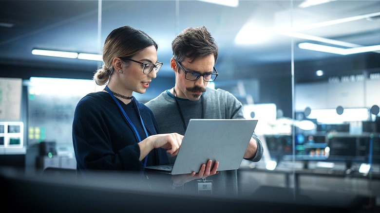 A man and woman looking at laptop