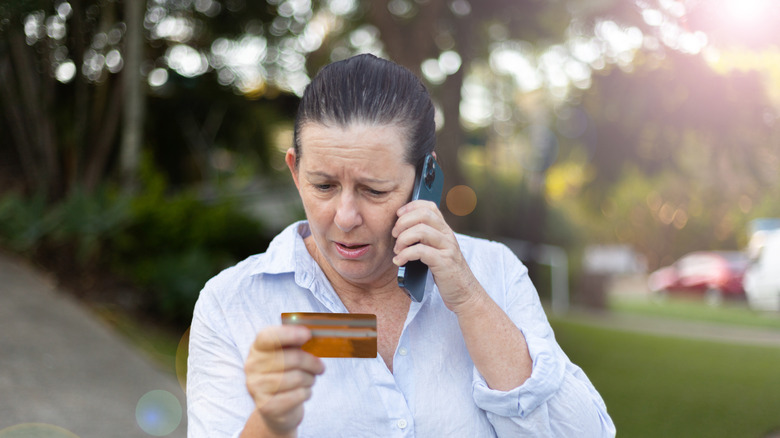 A concerned woman holding credit card