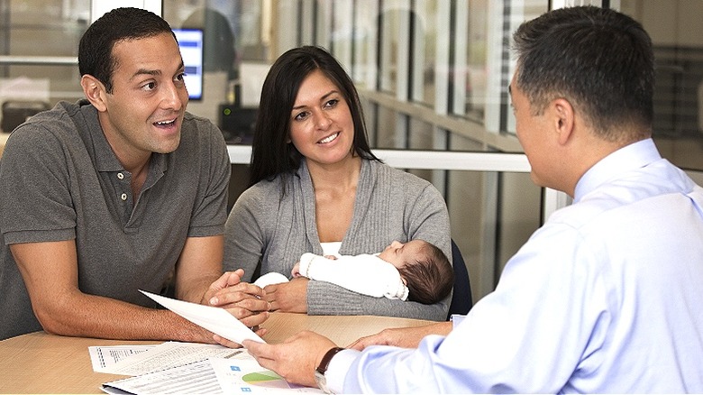 Couple with baby reviewing documents