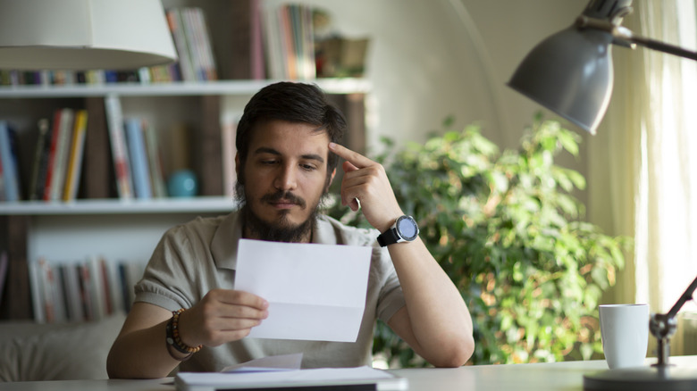 Card user reading a past due notice