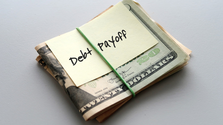 Debt payoff note on stack of bills