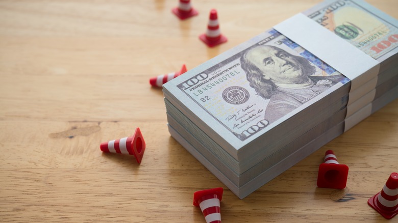 Stack of cash next to warning cones