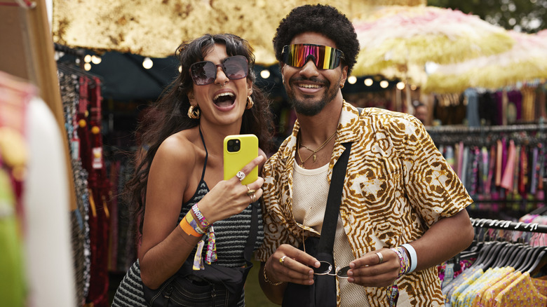 A stylish man and woman smiling in a clothing store