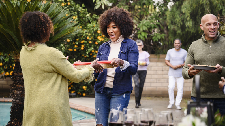 people arriving at a potluck dinner