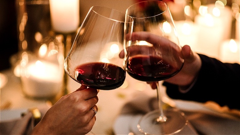 Couple toasting red wine glasses