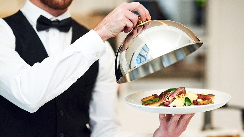 Waiter serving a fancy entree