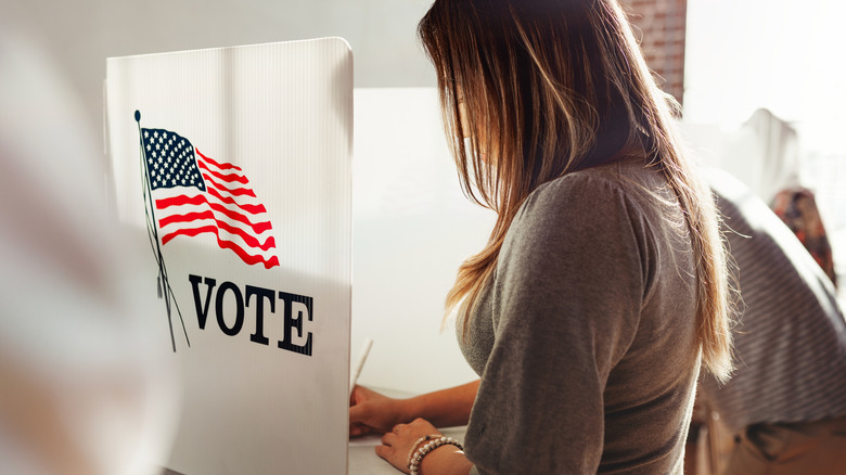 A woman voting in a voting booth