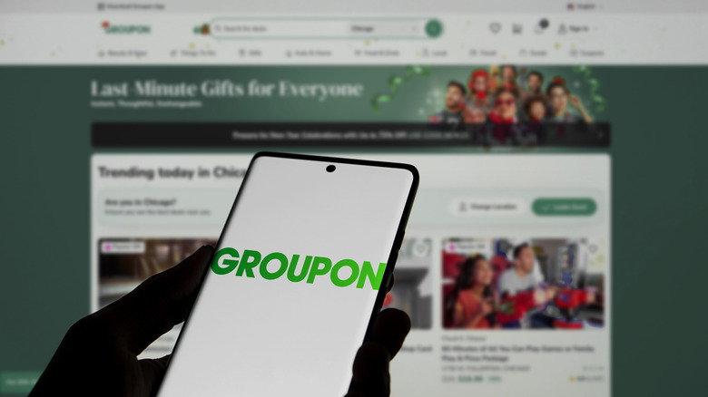 A phone and laptop screen displaying the Groupon site and app