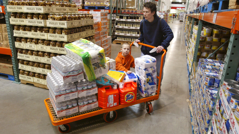 A woman pushing a loaded skid