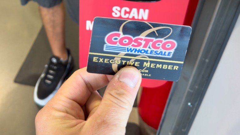 A hand holding a Costco Executive membership