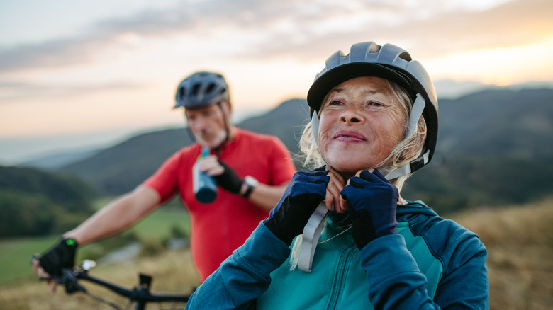 a couple wearing helmets and biking