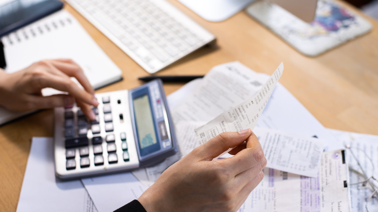 calculating expenses with calculator and receipts