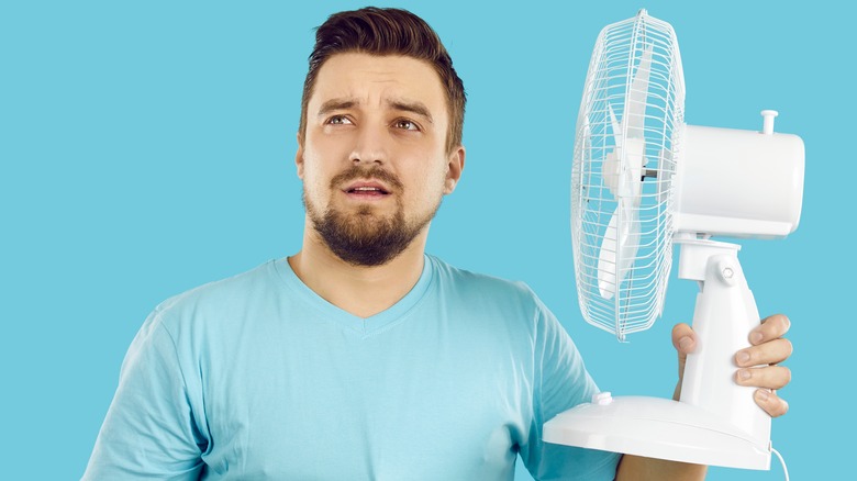 man with electric fan