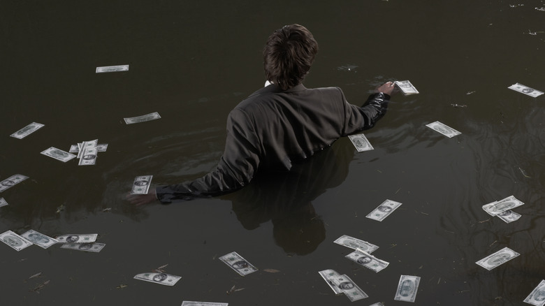 Man in water with floating cash