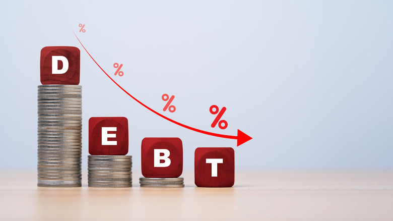 coins in decreasing stacks under blocks spelling debt