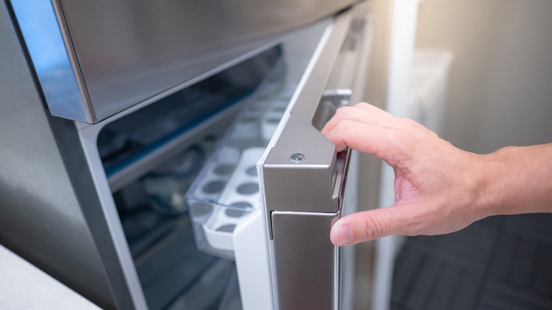 hand opening a fridge