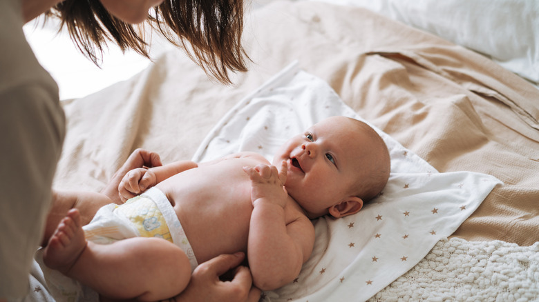 A mother changing her baby's diaper