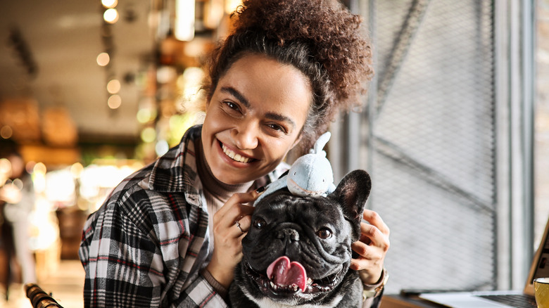 A smiling woman holding her dog 