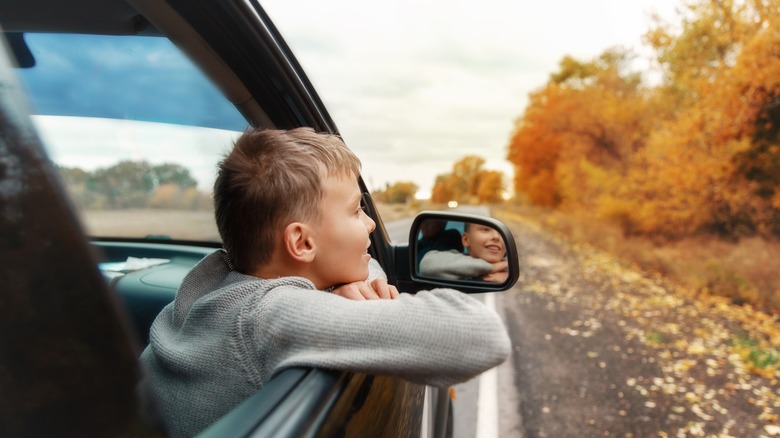 A little boy looking out a vehicles window