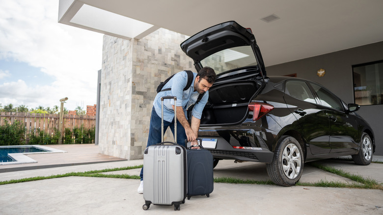 A man loading luggage into a car