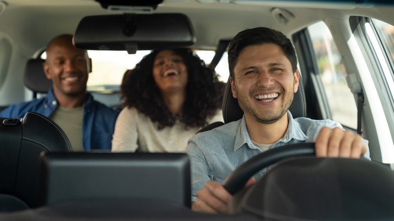 Three people laughing in a car