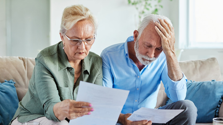 A concerned older couple reviewing documents