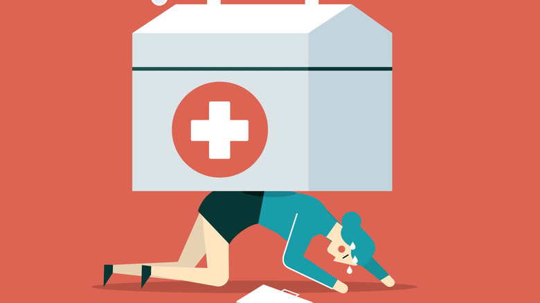 An image of a woman on her hands and knees with a large first aid kit on her back.