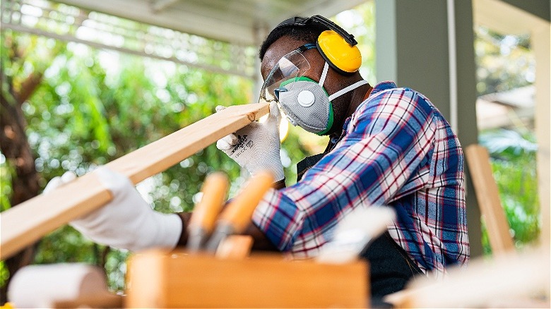 Person closely inspecting plywood