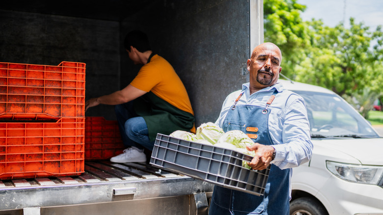 two men unloading fruits and vegetables