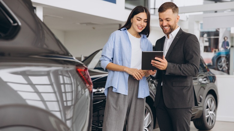 Car buyer consult with salesman on a car