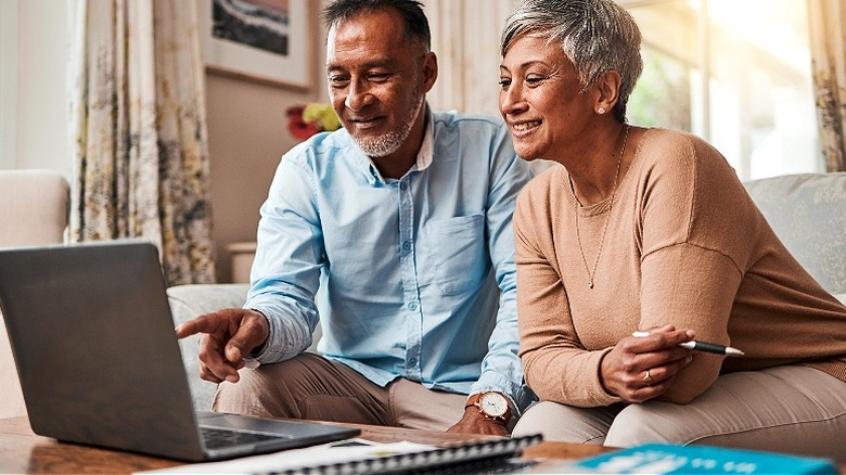 Older couple smiling at laptop