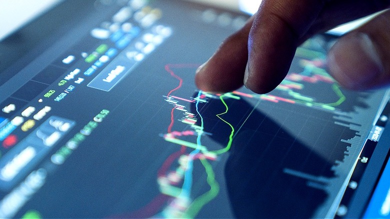 Hand tapping stock market chart