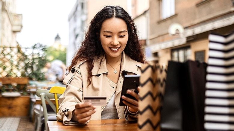 Person smiling, shopping on smartphone