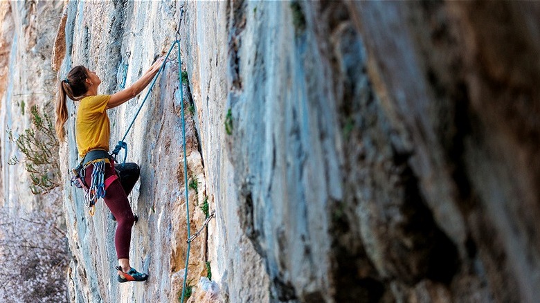 Rock climber heading up cliff