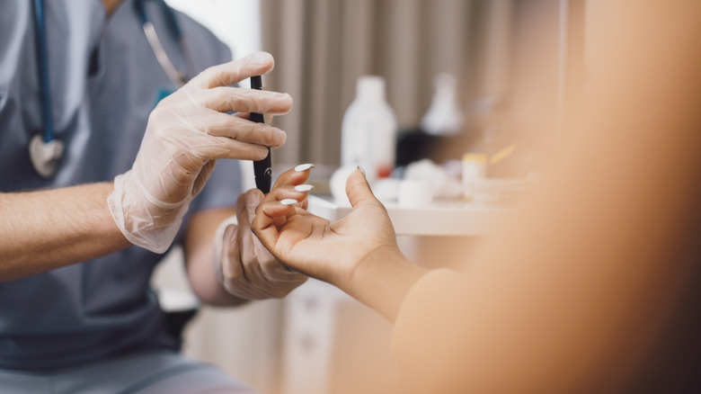 Medical professional performing a blood test with finger prick