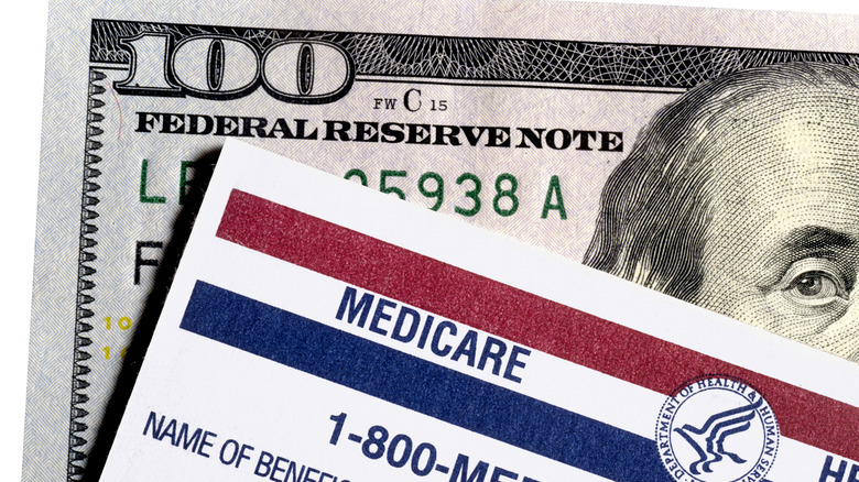 Medicare card sitting on a $100 bill.