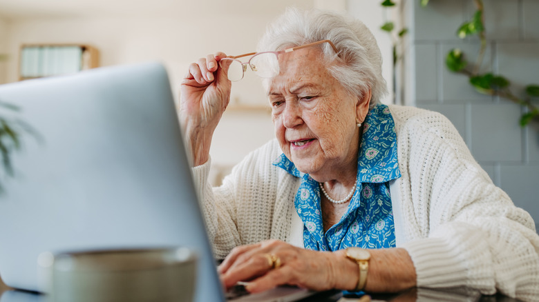 Senior woman reading her laptop screen