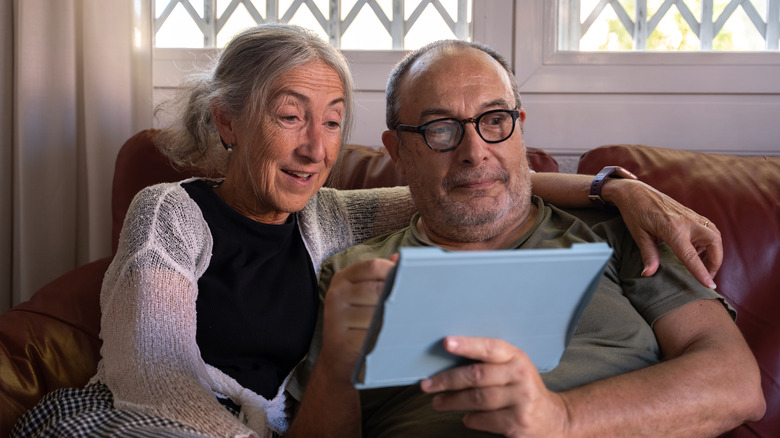 Retirees at home looking at a tablet