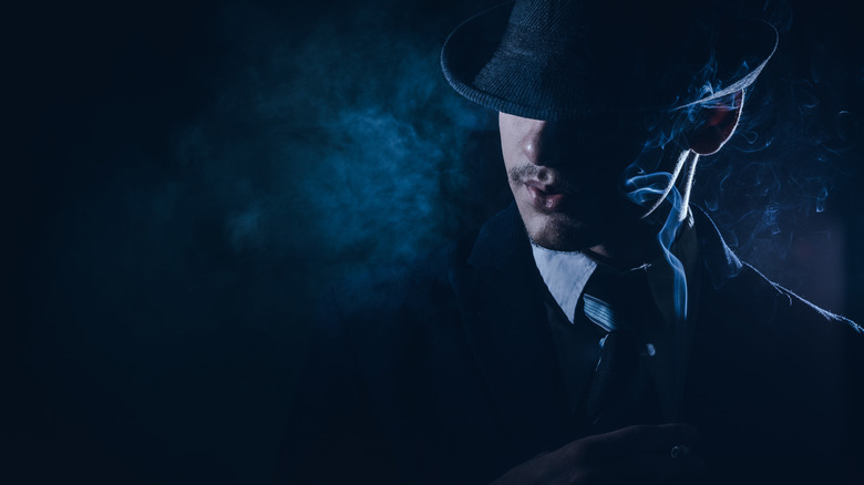 A 1930s-style noir detective, shrouded in blue smoke, shadows, and a fedora pulled low over his face.