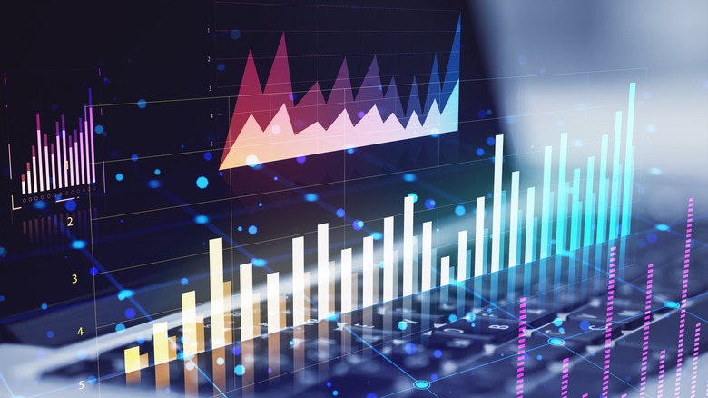 Colorful, three-dimensional financial graph information rises up from a laptop's keyboard.