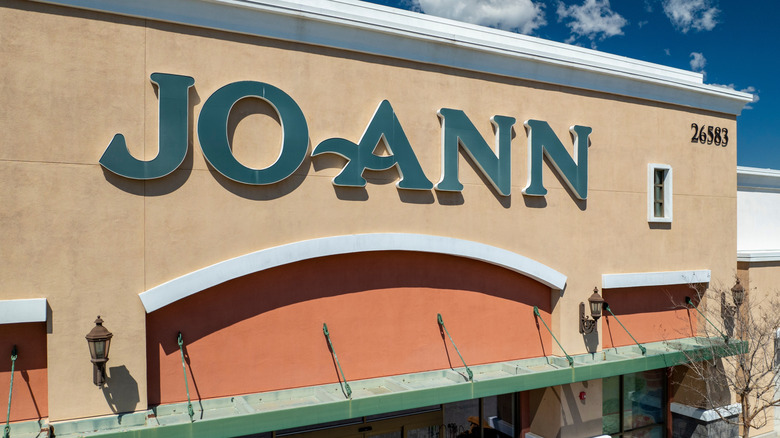 Storefront of a Joann Fabric and Craft store on a bright, sunny, blue-sky day.