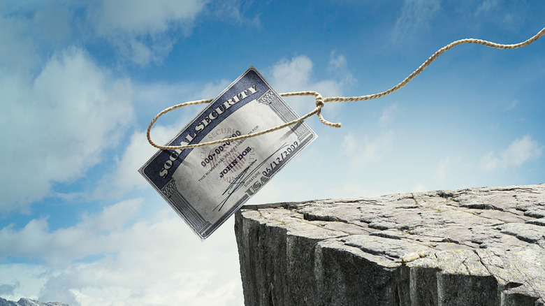 a Social Security card hanging over a cliff