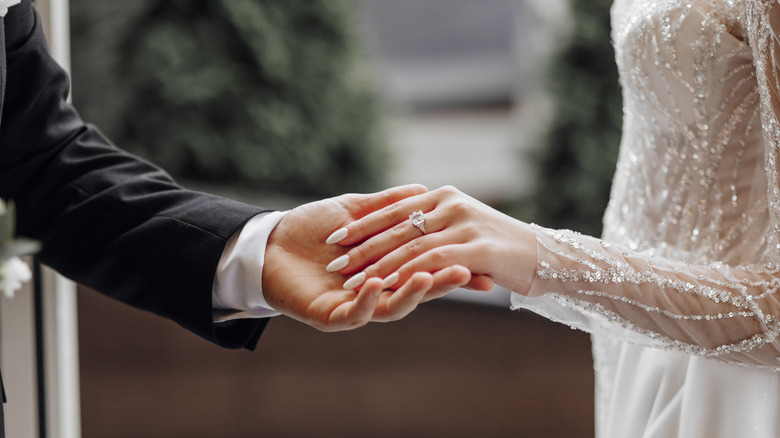 man and woman's arms in wedding attire