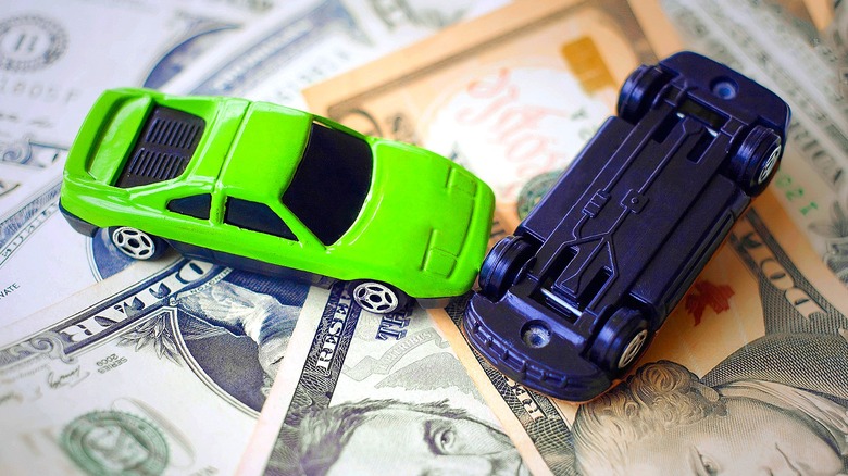 toy cars displayed on money