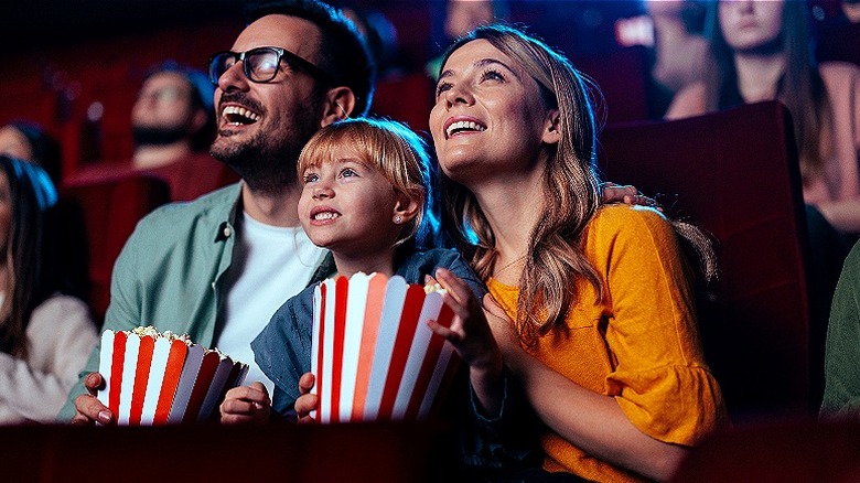 Family watching movie with popcorn