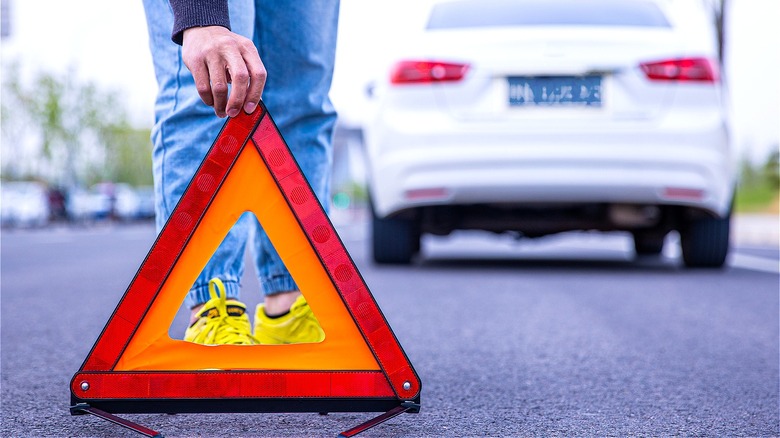Person displaying roadside assistance triangle