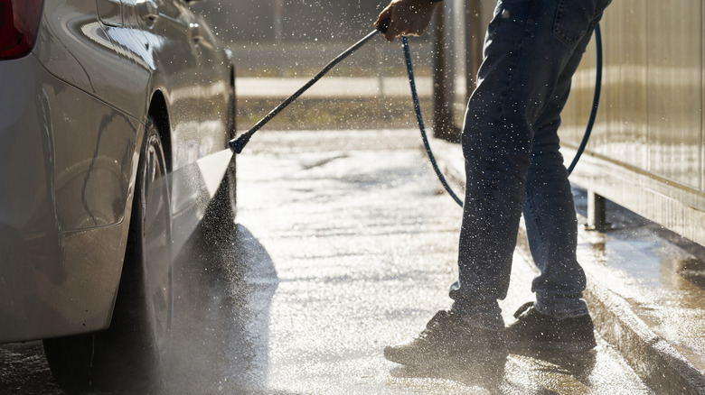 a person washing a car's wheels with hydrojet