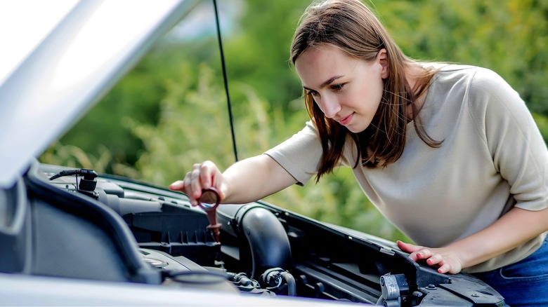 Person checking car's oil level
