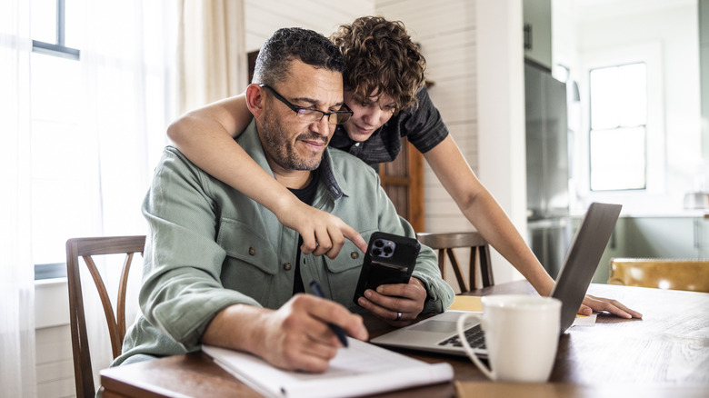 Father working from home with teenage son